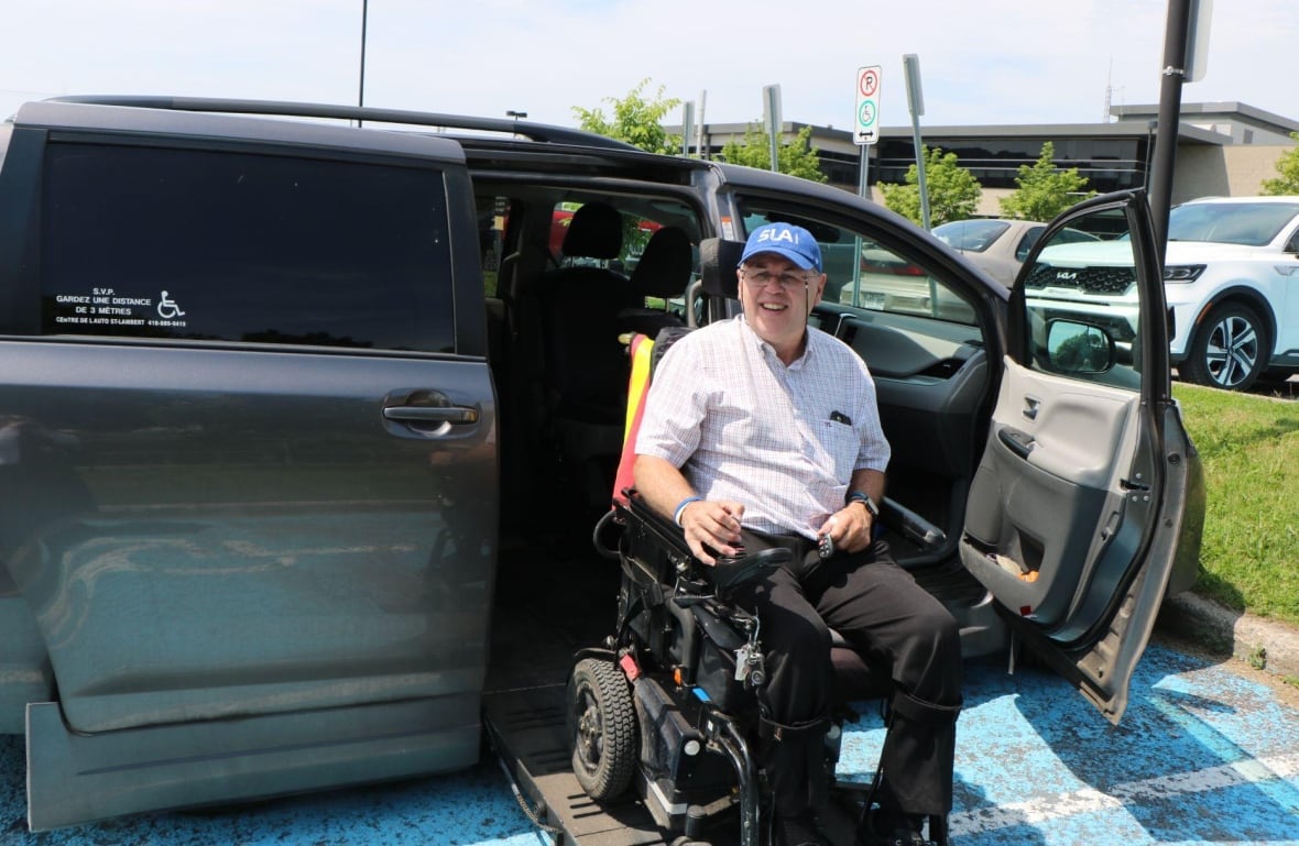 A man in a wheelchair getting into a car